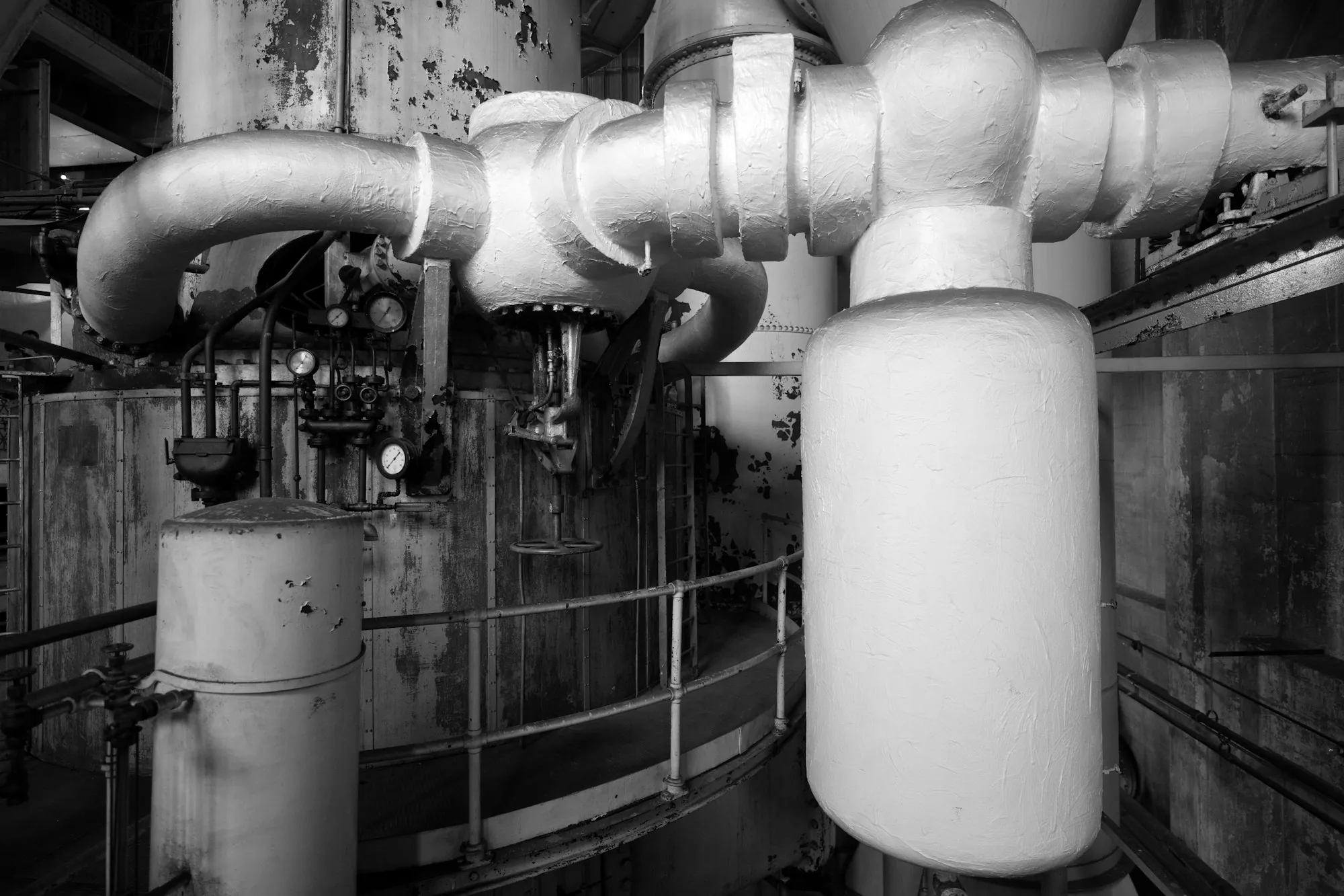 Black and white view of a boiler room with pipes